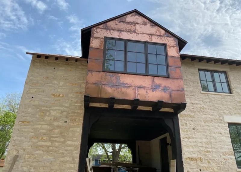 Copper metal panel facade on a stone building for Roof Repair in Scio
