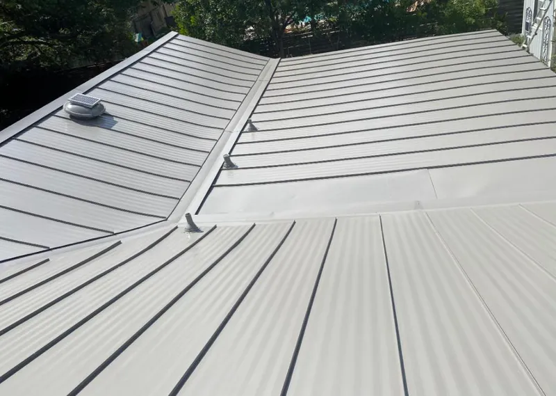 Solar attic fan installed on a metal roof for Roof Ventilation in Scio
